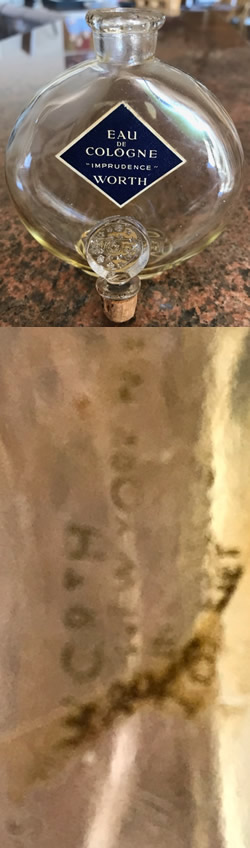 Close Copy Of Je Reviens-5 Perfume Bottle For Worth Marked With Sliver Moon and Stars Stopper And Molded WORTH To The Front Face. Believed Made For Worth By An Unknown U.S. Glassmaker During The War With Cork Stopper. Also Showing Clear Smeared Label On Reverse.